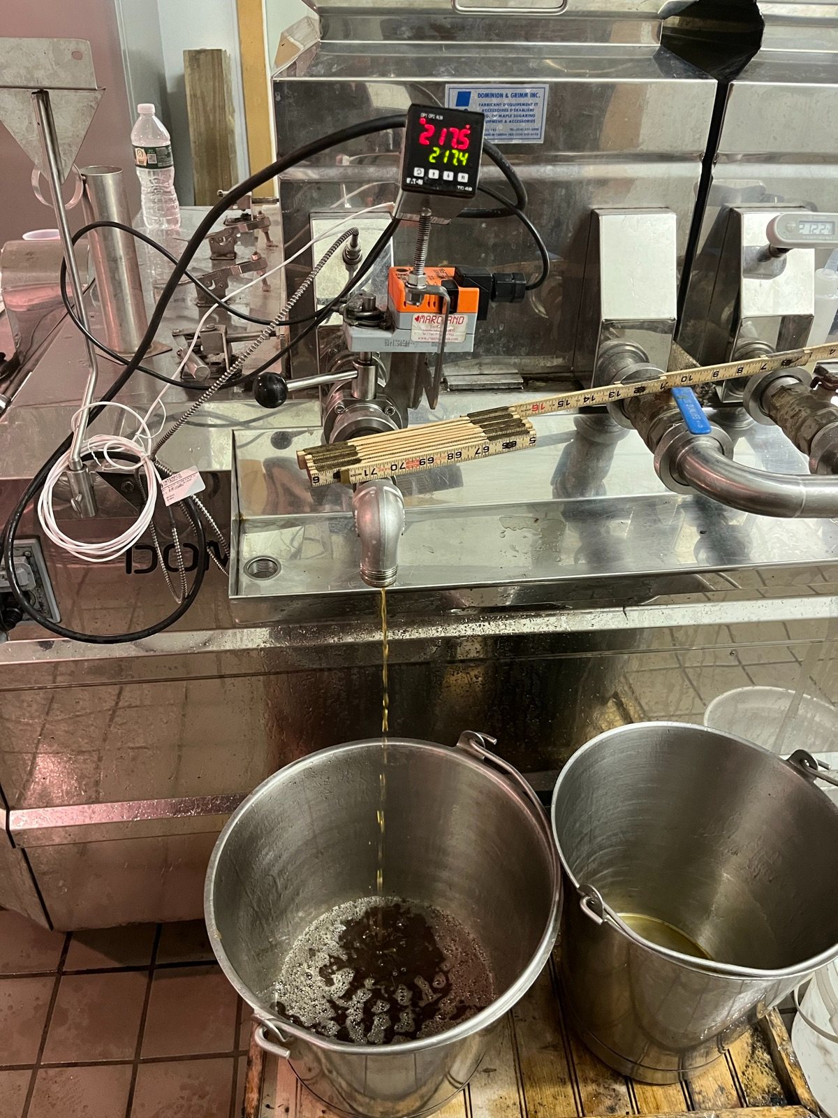 Finished syrup being drawn off the evaporator into a pail